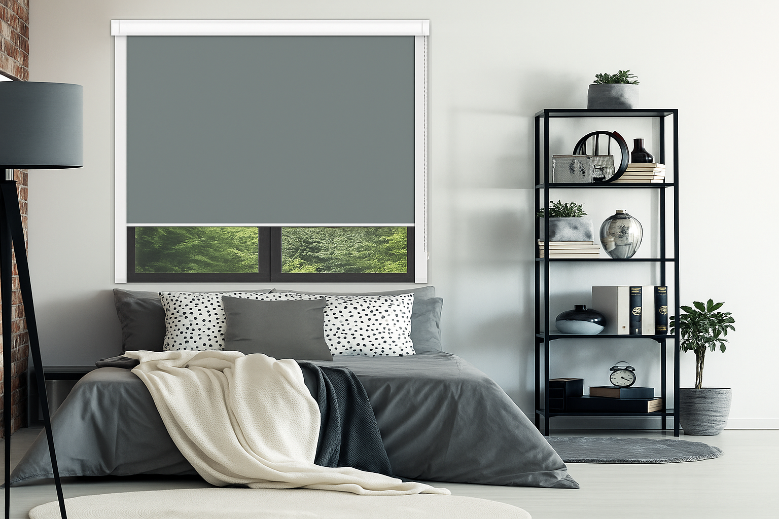 Modern bedroom with grey blackout roller blind, grey bedding, decorative pillows, and a black metal shelving unit with plants and decor.
