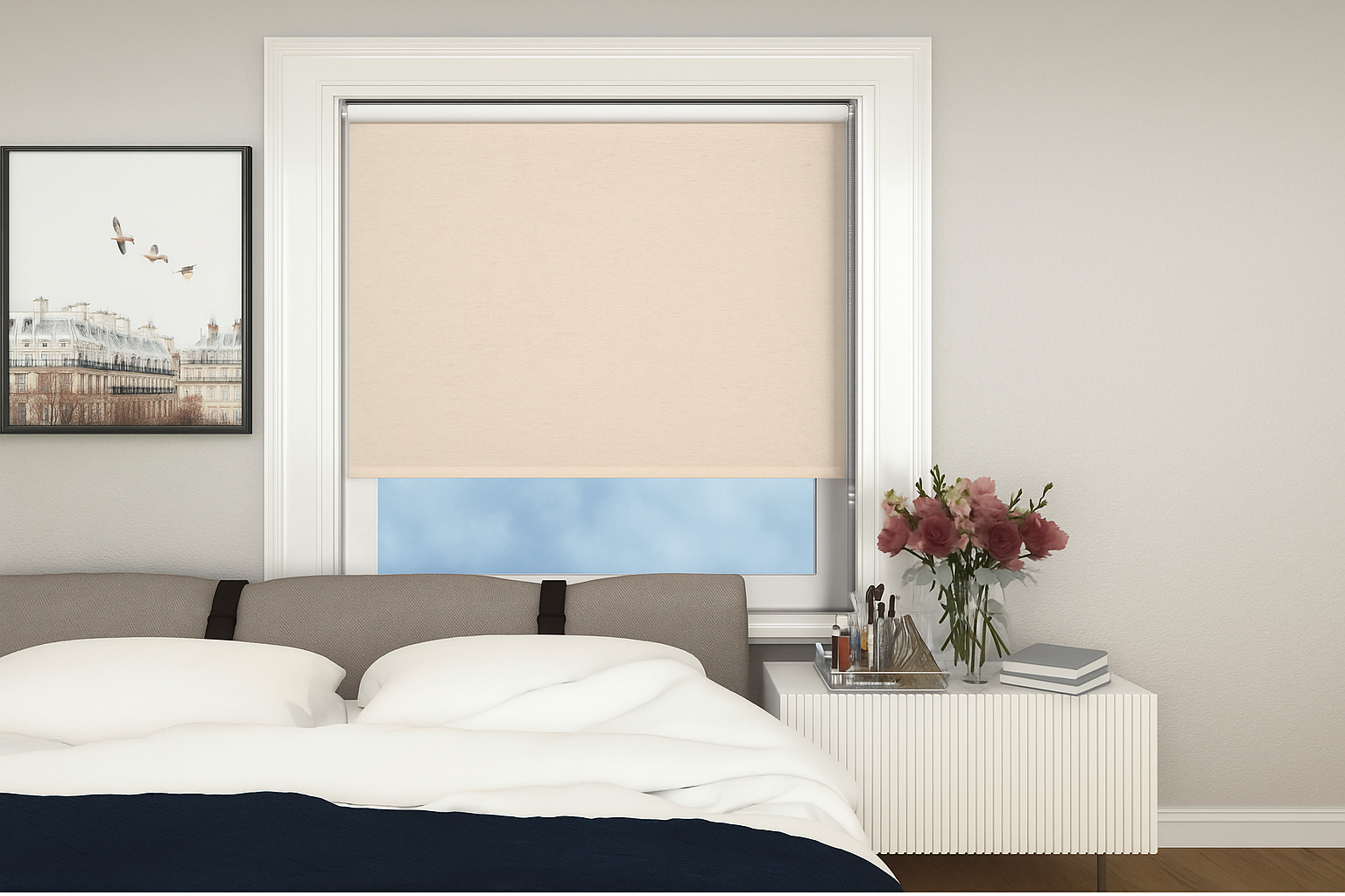 A modern bedroom interior featuring a beige roller blind over a window, a gray upholstered headboard, and a nightstand with flowers and decor items.