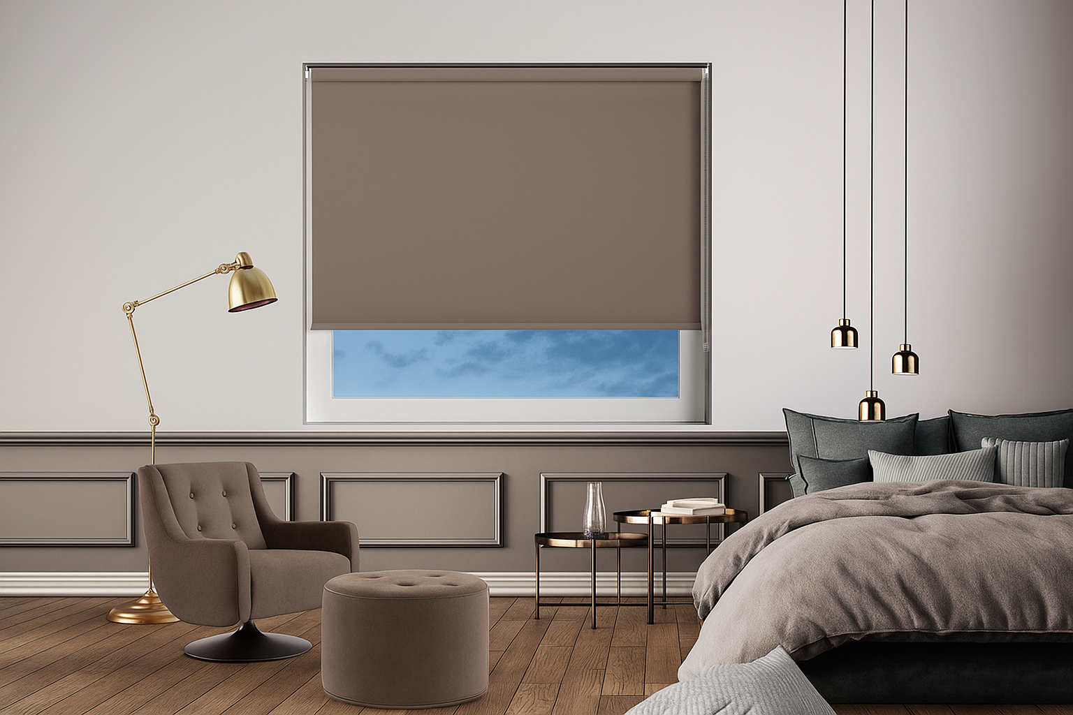 A modern bedroom interior with a Bedtime Clay Roller Blind partially lowered, featuring a taupe blind over a window showing a blue sky, paired with a cozy bed, accent lighting, and a reading chair with a matching ottoman.