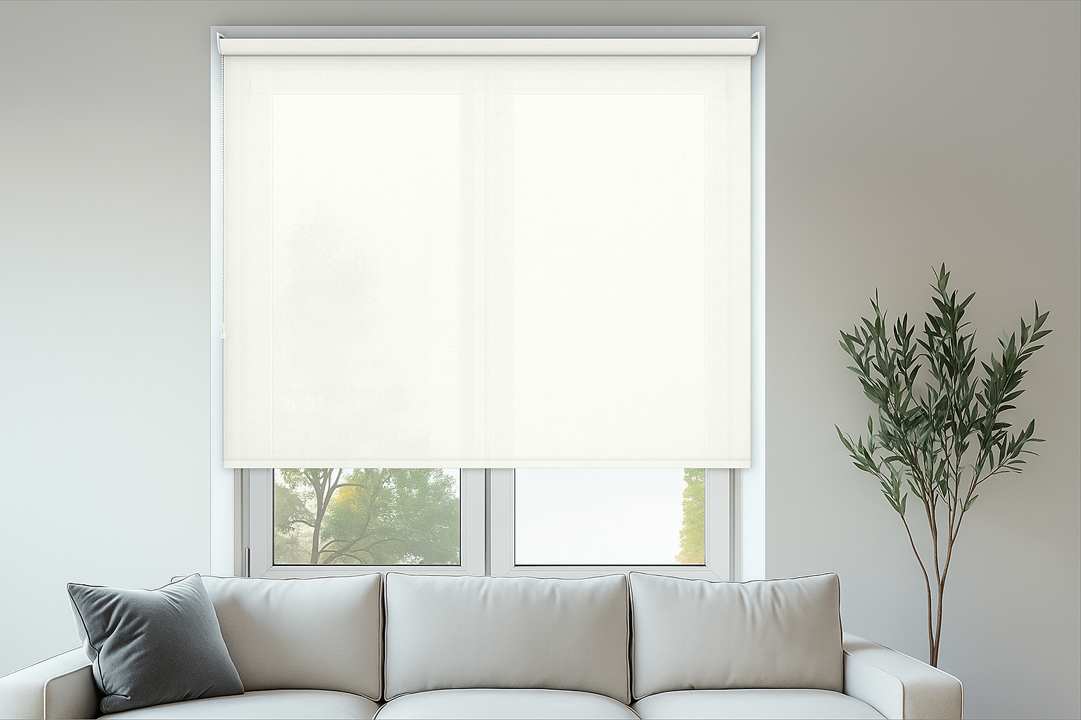 A modern living room featuring a light grey sofa and a Tobago White Roller Blind filtering daylight through a large window, creating a clean and airy ambiance.